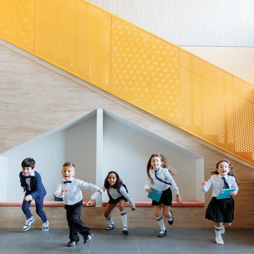 Group of diverse children playing and stretching on amber colored mats.